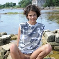 Little nude girl playing and swimming at the beach