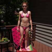 Bikini girl having fun with a cucumber